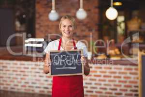 Pretty waitress with a chalkboard open sign