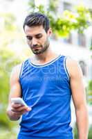 An handsome athlete using his phone