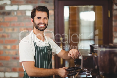 Smiling barista preparing a coffee