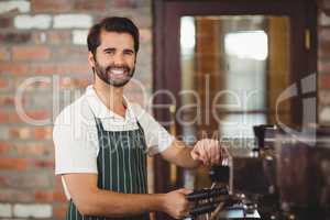 Smiling barista preparing a coffee