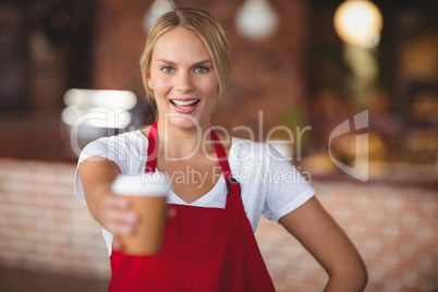 Pretty waitress handing a mug of coffee