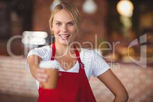 Pretty waitress handing a mug of coffee
