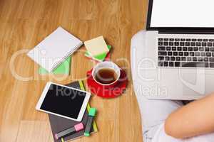 Overhead shot of woman, coffee, laptop, and tablet