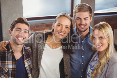 Smiling friends putting arms around each other