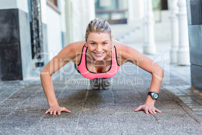 A pretty woman doing push-ups on the floor