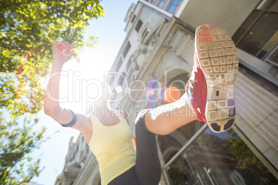 A pretty woman jumping in the street