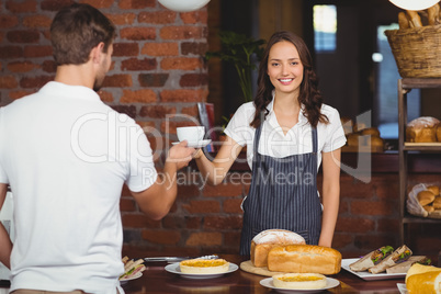 Pretty smiling barista serving a customer