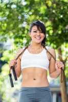 Portrait of smiling athletic woman with skipping rope looking at