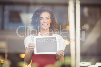 Smiling waitress showing a digital tablet