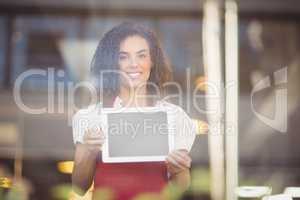 Smiling waitress showing a digital tablet