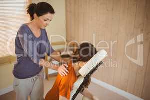 Young woman getting massage in chair