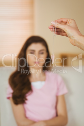 Hypnotherapist holding pendulum before her patient