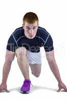 Muscular rugby player in running stance