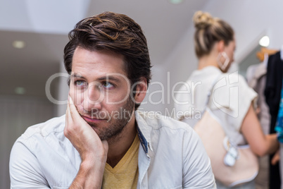 Bored man sitting in front of his girlfriend