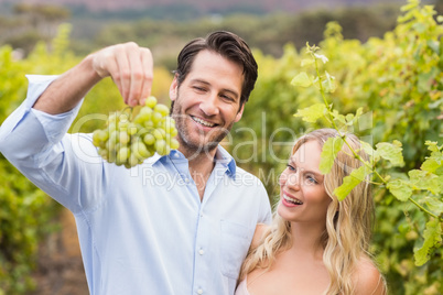 Young happy couple looking at grapes