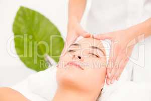 Attractive woman receiving facial massage at spa center