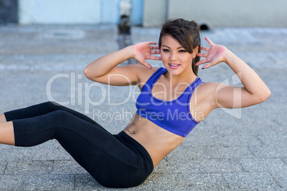Smiling athletic woman doing sit-ups