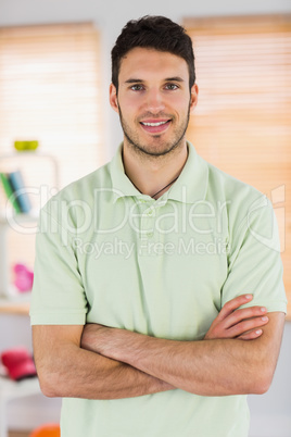 Portrait of smiling handsome masseur with arms crossed