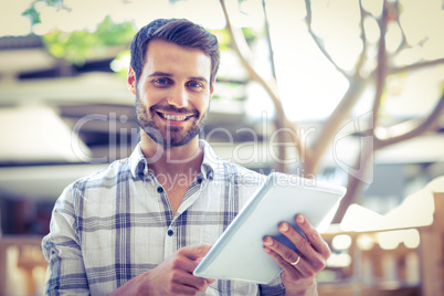 Hipster man using tablet computer in the city