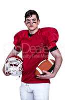 American football player holding helmet and a ball