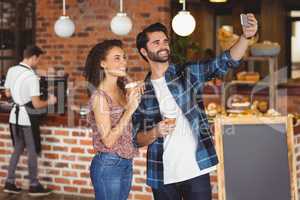 Smiling hipster couple taking selfies