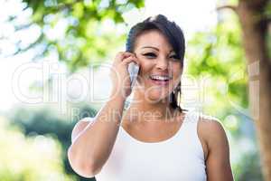 Portrait of smiling athletic woman phoning with smartphone
