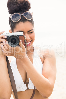 Pretty hipster in bikini taking picture