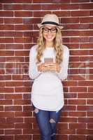 Gorgeous smiling blonde hipster using smartphone
