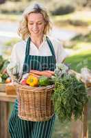 Smiling farmer woman holding a vegetable basket