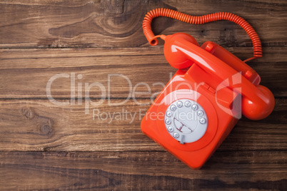 Red telephone on wooden table