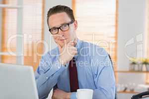 Happy businessman sitting at his desk