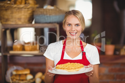 Pretty waitress holding a plate of cake