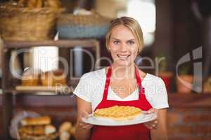 Pretty waitress holding a plate of cake