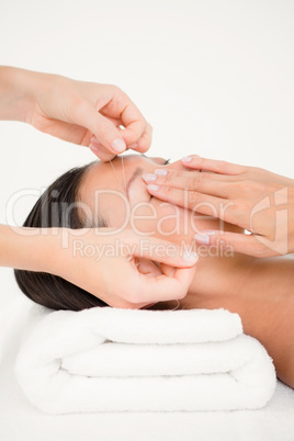 Hands threading beautiful womans eyebrow