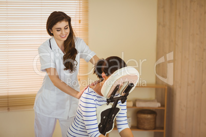 Young woman getting massage in chair