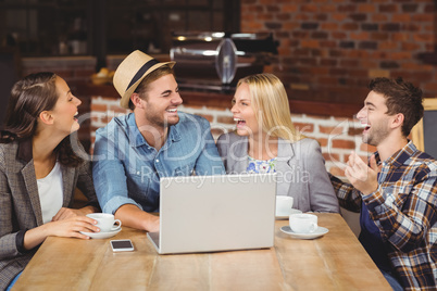 Smiling friends drinking coffee and laughing