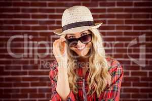 Gorgeous smiling blonde hipster posing with sunglasses