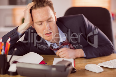 Exhausted businessman sleeping at his desk