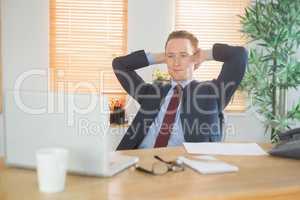 Relaxed businessman sitting back at desk