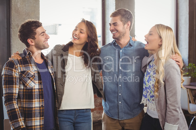 Smiling friends laughing and putting arms around each other