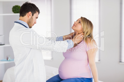 Doctor examining neck of pregnant patient