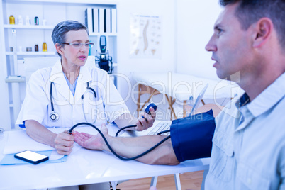 Doctor checking blood pressure of her patient