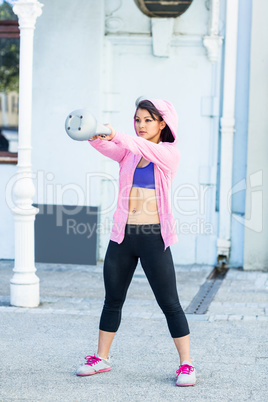 Athletic woman swinging kettlebell