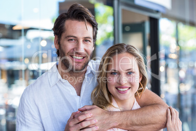 Smiling man putting arm around his girlfriend