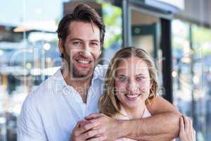 Smiling man putting arm around his girlfriend