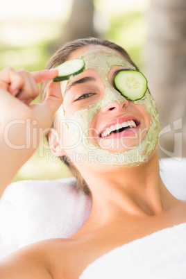 Pretty woman withdrawing a cucumber on her eye