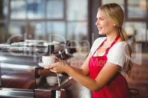Pretty barista handing a cup of coffee