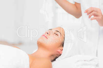 Beautiful woman lying on massage table at spa center