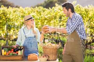 Happy farmer couple handing bread