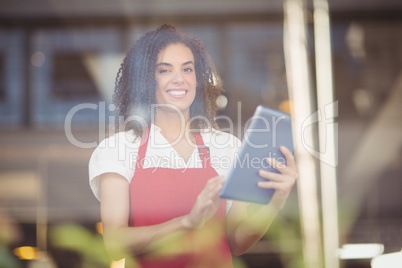 Smiling waitress using a digital tablet